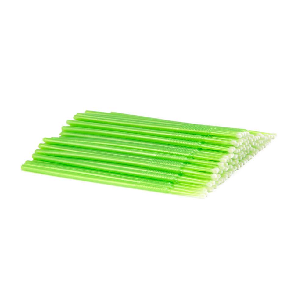 A collection of green micro dental applicators with tufted tips, made of flexible plastic.